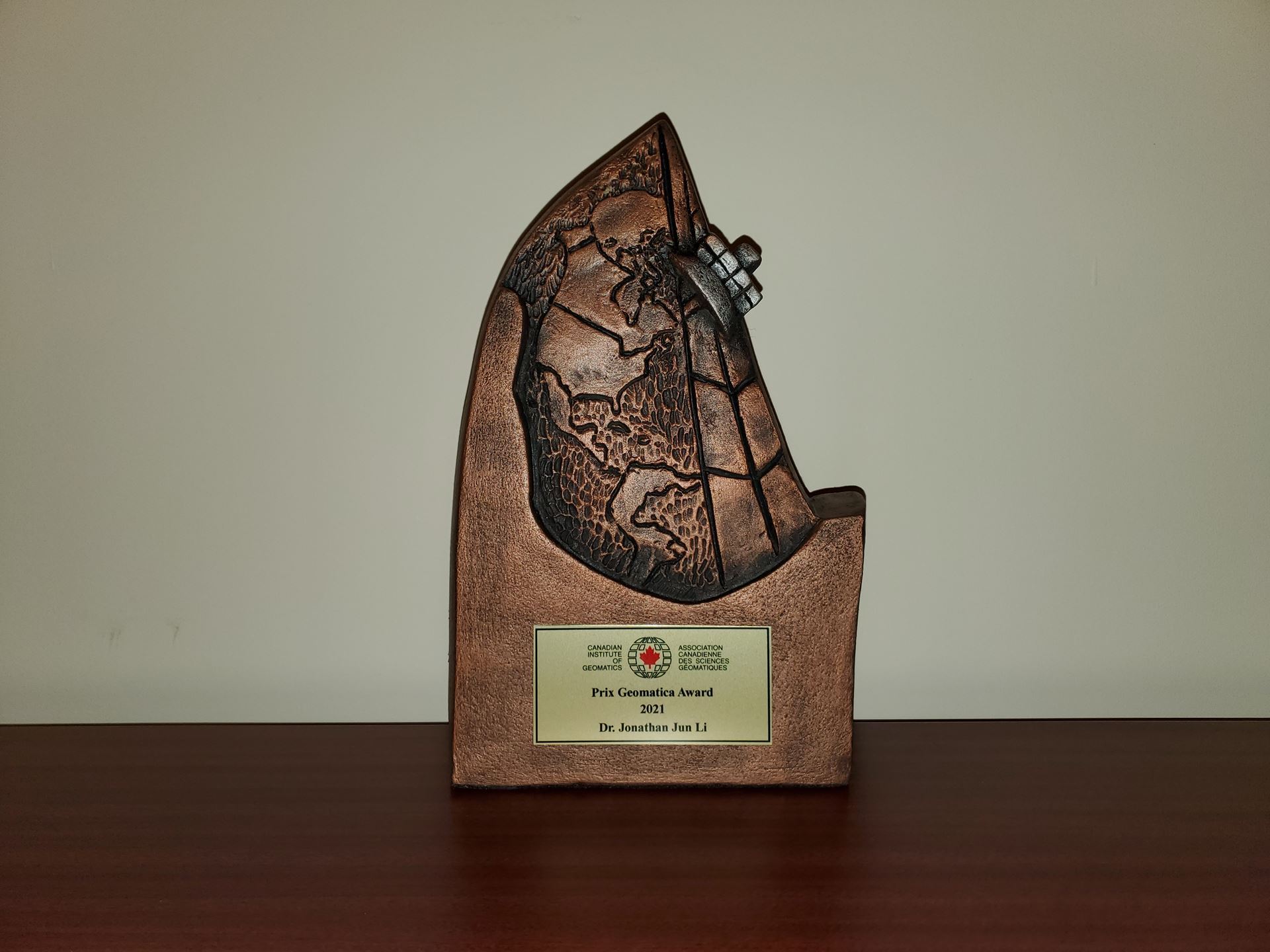 Photo of Geomatica Award - front of 3D wood carving of a map